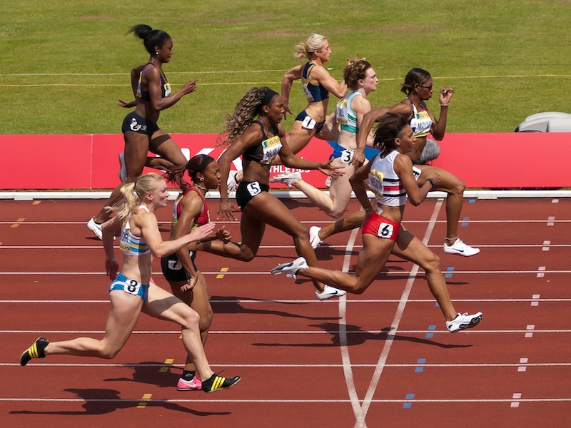 Women running on a track field.