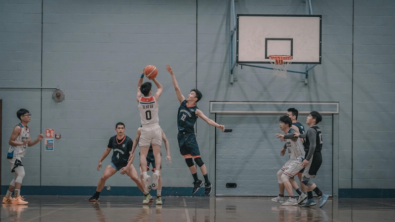 Men playing a game of basketball indoors
