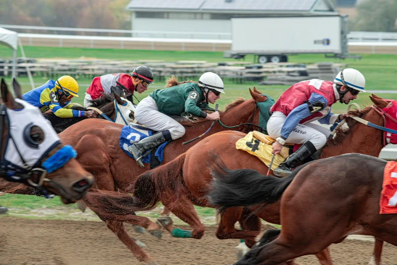 A group of jockeys in the middle of a horse race